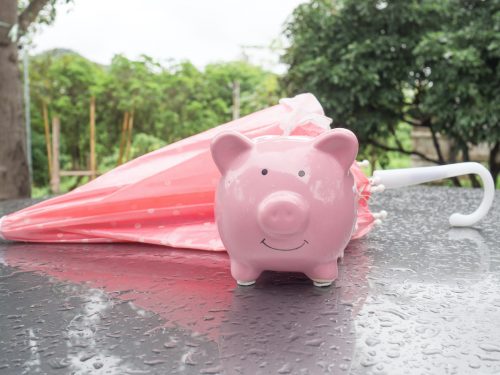 Piggy bank representing a Gen Xers retirement savings next to a closed umbrella